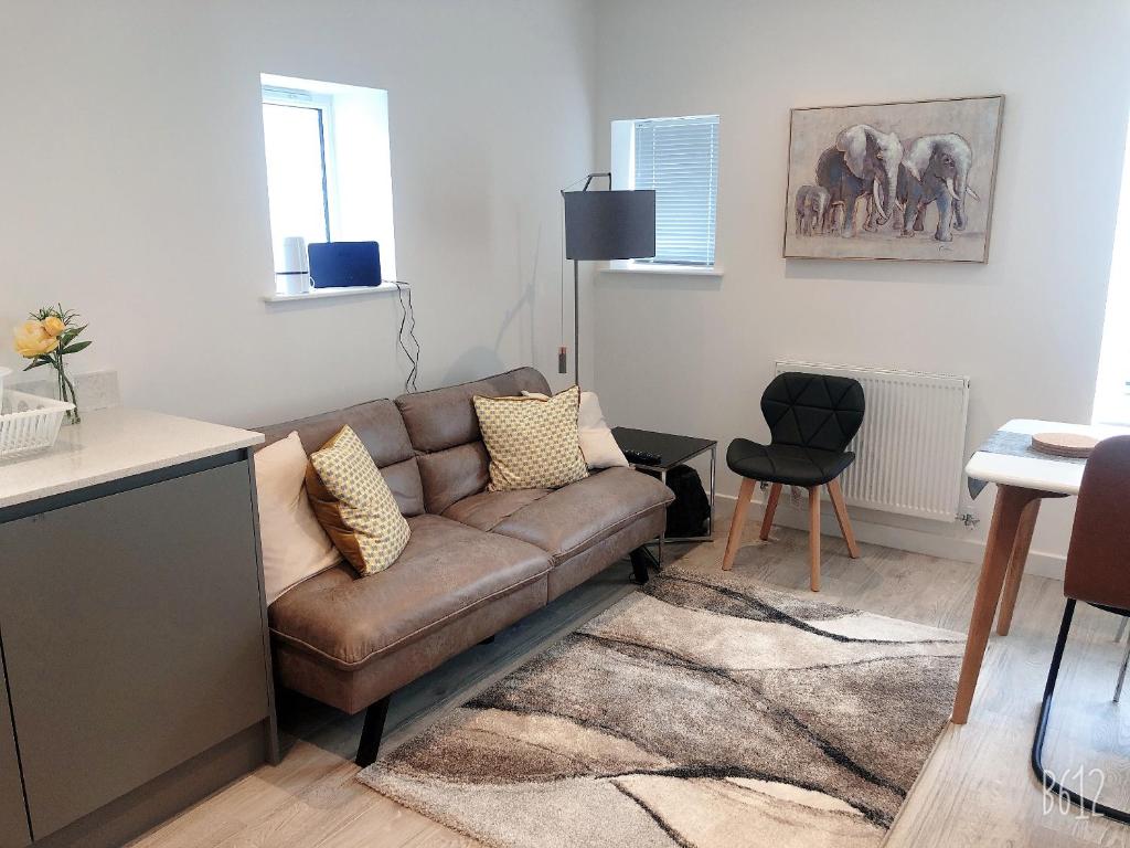 a living room with a brown couch and a table at Cottage House - Preston Village - Preston Park in Brighton & Hove