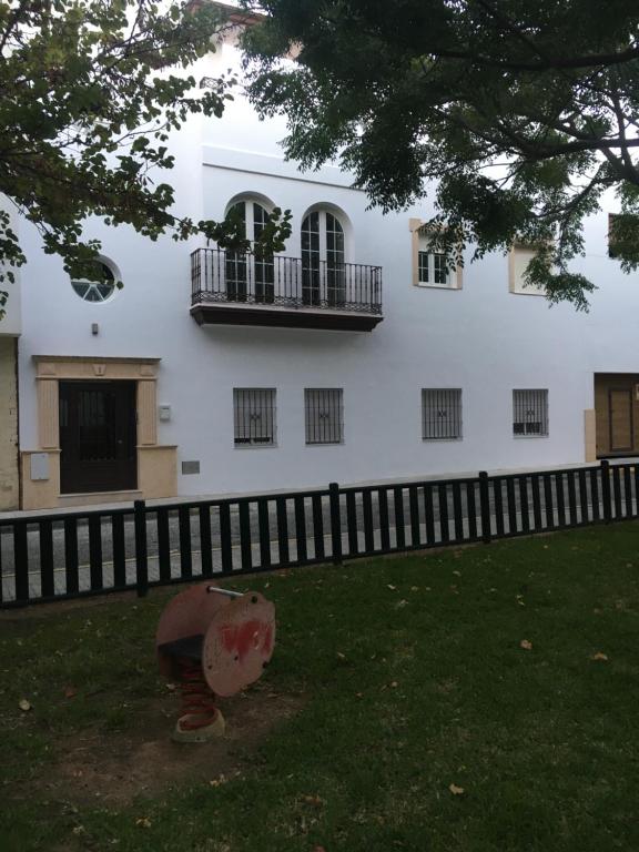 un edificio blanco con 2 balcones en un lateral en alojamiento saturno1, en Conil de la Frontera