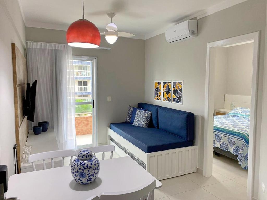 a living room with a blue couch and a bed at Boulevard Riviera Flat in Riviera de São Lourenço