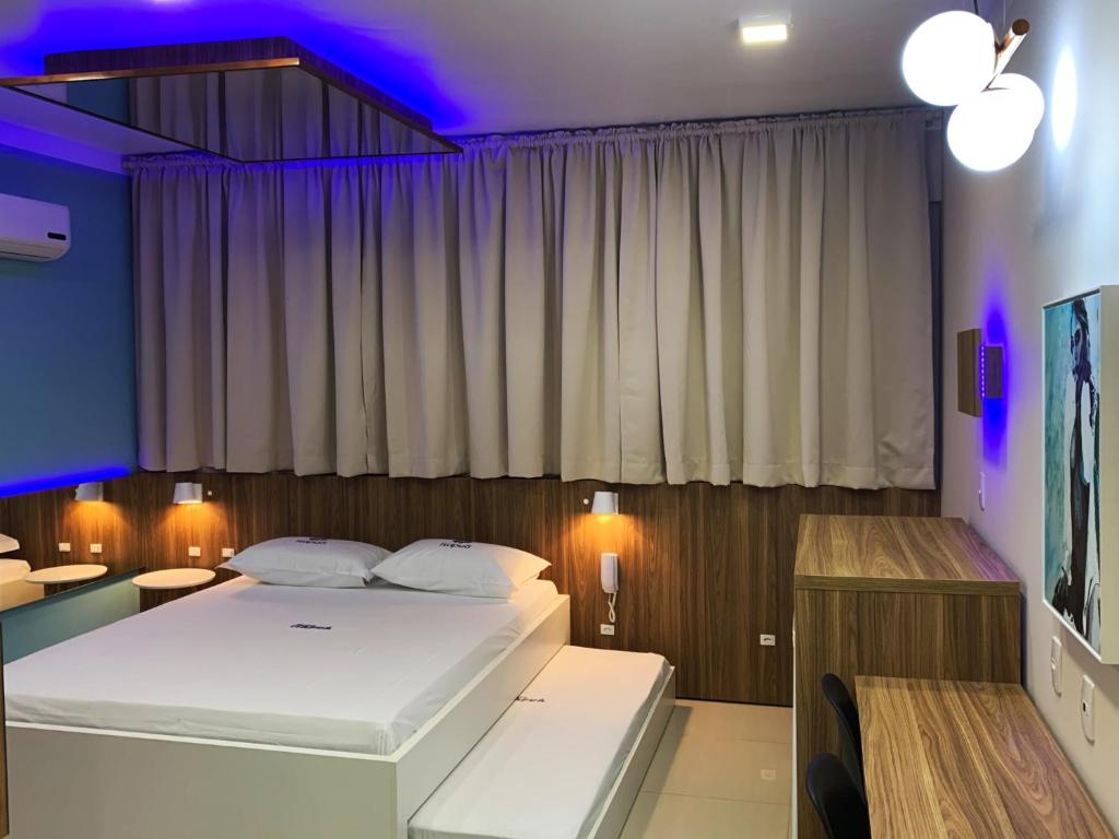 ein Schlafzimmer mit einem großen Bett und einer violetten Decke in der Unterkunft Itapuã II Fx São Sepé in Santa Maria