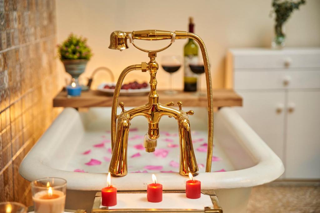 La salle de bains est pourvue d'une baignoire avec des bougies. dans l'établissement Hotel Vintage "Rialto", à Quetzaltenango