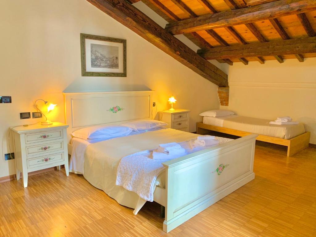 a bedroom with a white bed and two night stands at Le Stanze sul Po in Ferrara