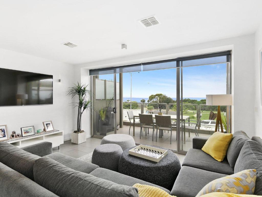 a living room with a couch and a table at Waterfront Two in Lorne