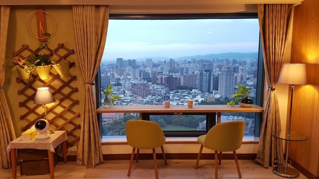 Zimmer mit einem großen Fenster und Stadtblick in der Unterkunft 雲雀高樓景觀公寓 in Taichung
