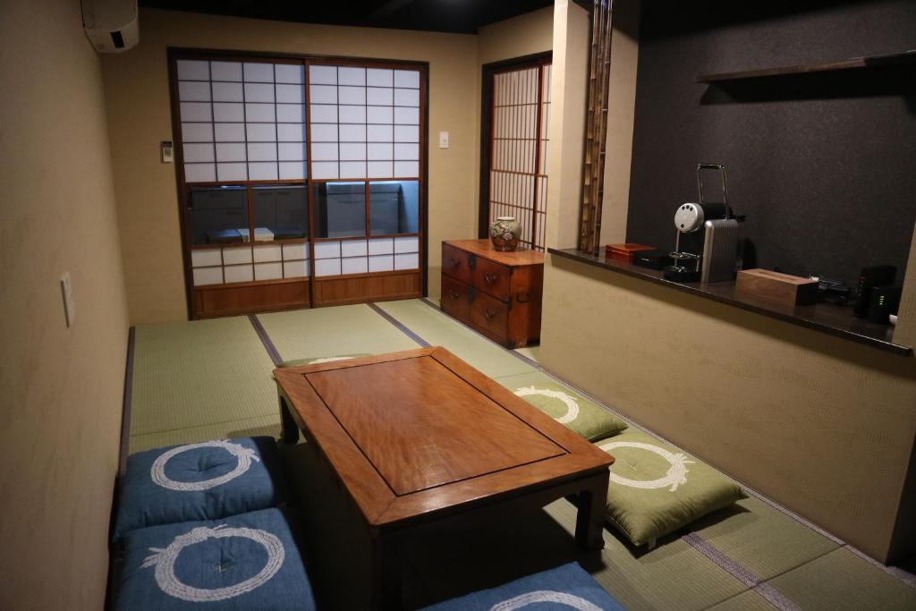 a living room with a wooden table and a room at Souwaan in Takayama