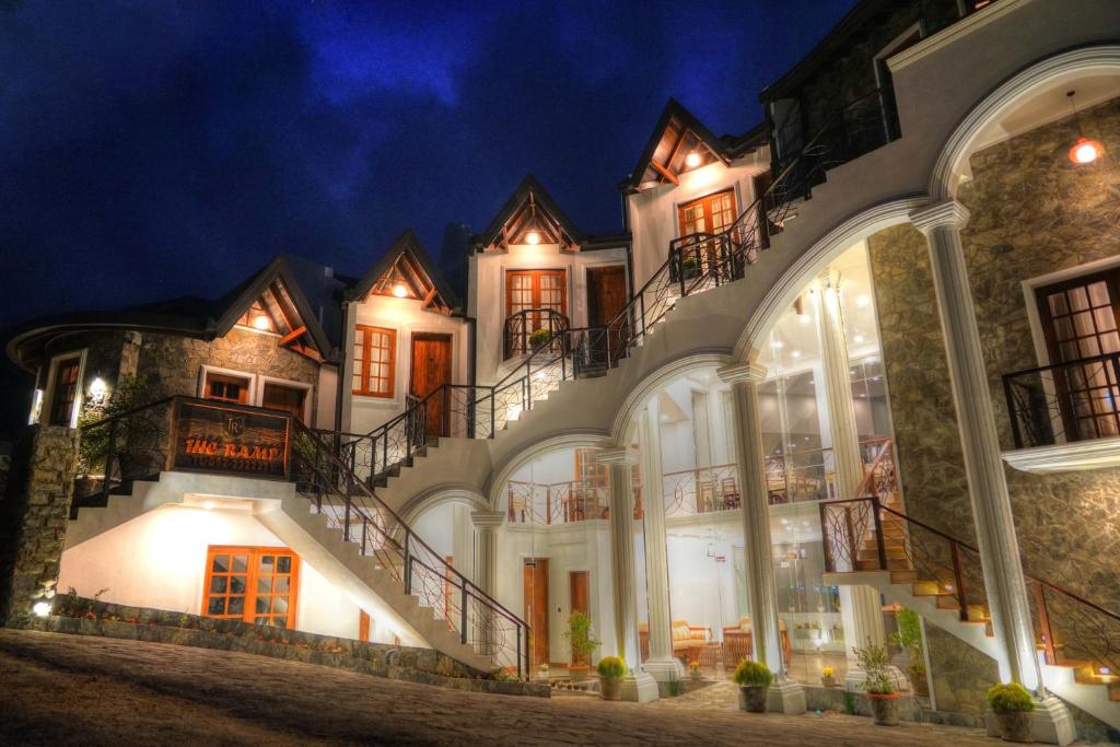 a large white building with stairs on it at night at The Ramp in Nuwara Eliya