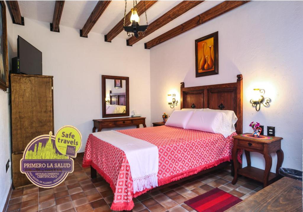 a bedroom with a bed and a tv in it at El mesón del Quijote in San Miguel de Allende
