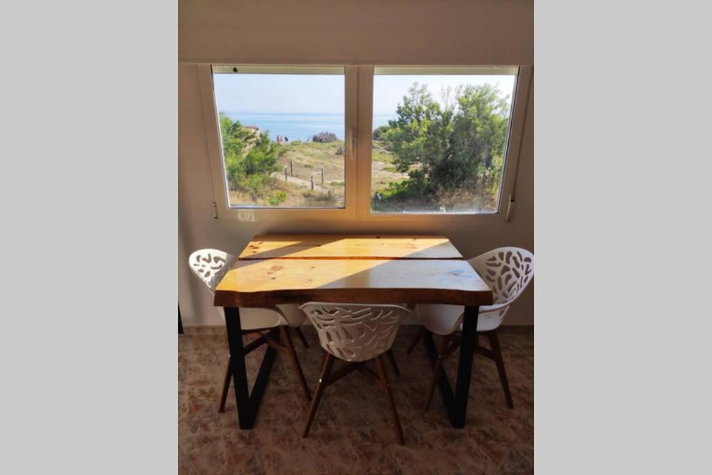 een tafel en stoelen in een kamer met een raam bij Apartamento primera línea in Denia