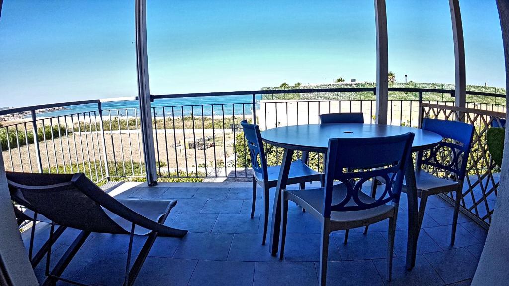 un tavolo e sedie su un balcone con vista sull'oceano di Asinaro Residence - Fronte Mare a Calabernardo