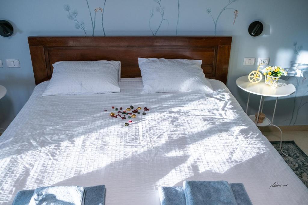 Una cama con un ramo de flores. en צימר רומנטי ואיכותי בפרדס חנה La Baita, en Pardes H̱anna