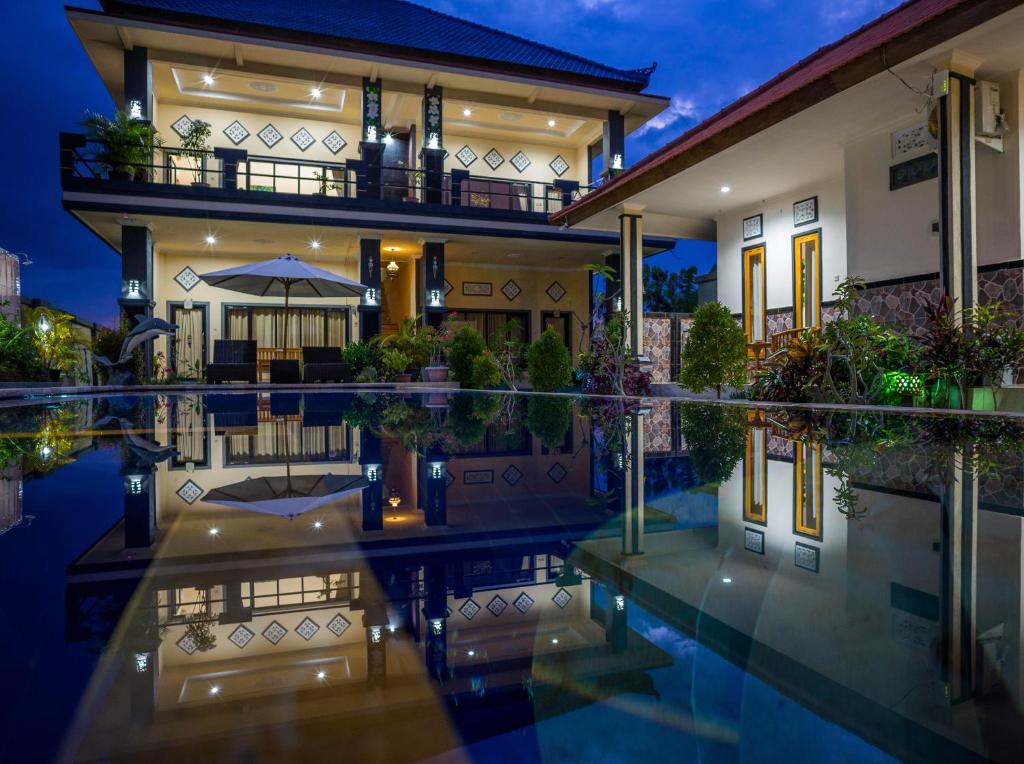 una casa con piscina por la noche en Summer Guesthouse Lovina en Lovina
