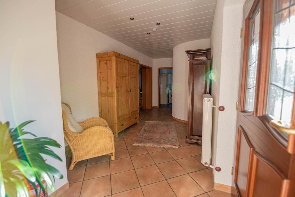 a hallway with a cabinet and a chair in a room at Ferienhaus bis 10 Personen und 2,5 Schlafzimmern in Geisenheim