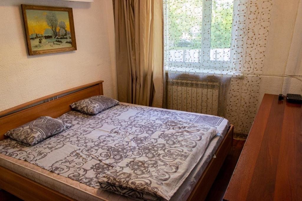a bedroom with a bed with two pillows and a window at Nuri Hotel Стадион in Karagandy