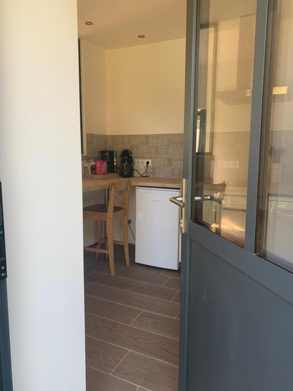 a door leading into a kitchen with a table at L&#39;Arbois 1876-La Verrière- in Arbois