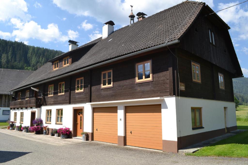 ein großes schwarzweißes Gebäude mit zwei Garagentüren in der Unterkunft Ferienwohnung Ertlerhof in Ranten