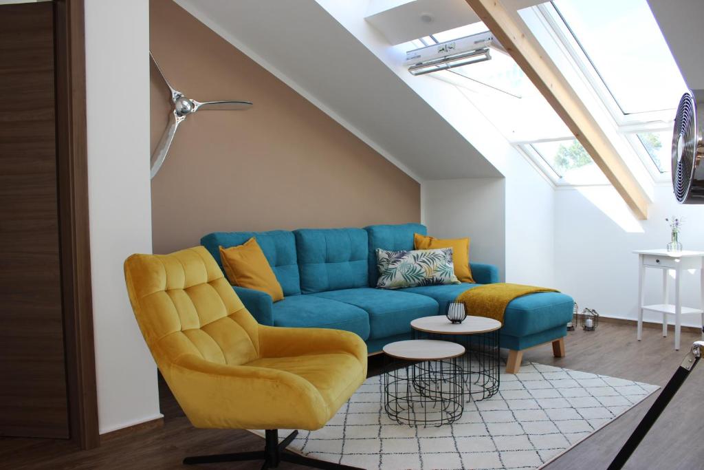 sala de estar con sofá azul y silla amarilla en Ferienwohnung „Otto Lilienthal“, en Anklam
