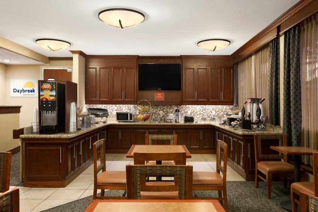a kitchen with wooden cabinets and a table with chairs at Days Inn by Wyndham Las Cruces in Las Cruces