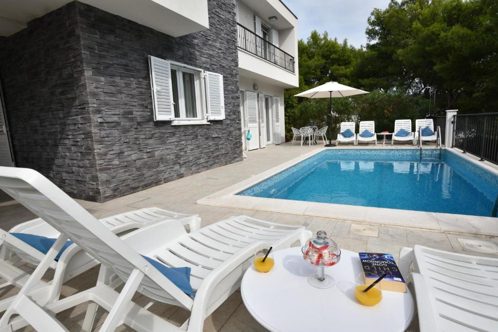 a group of chairs and a swimming pool at Apartments Nika in Primošten