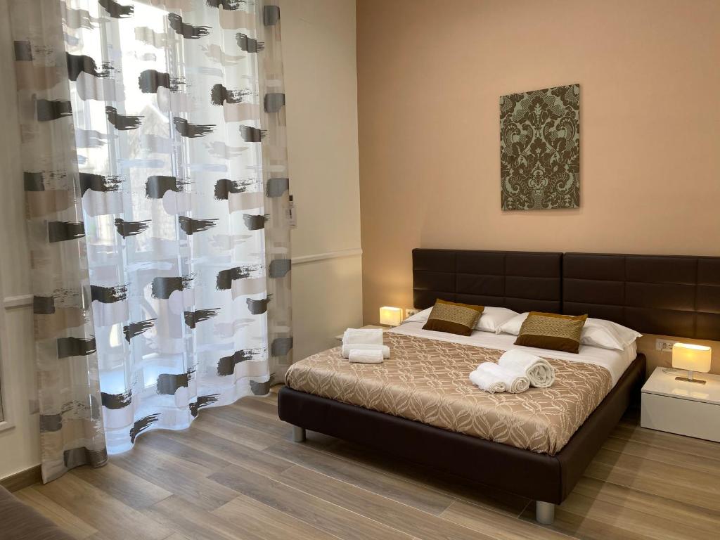 ナポリにあるLuxury B&B Sun Art Naplesのベッドルーム1室(ベッド1台、タオル2枚付)