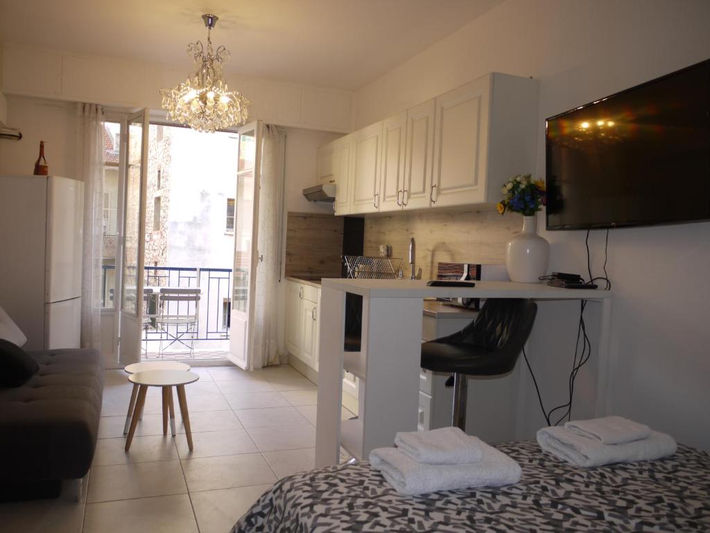 una cucina e un soggiorno con tavolo e sedie di Beach - a modern studio flat in central Nice a Nizza