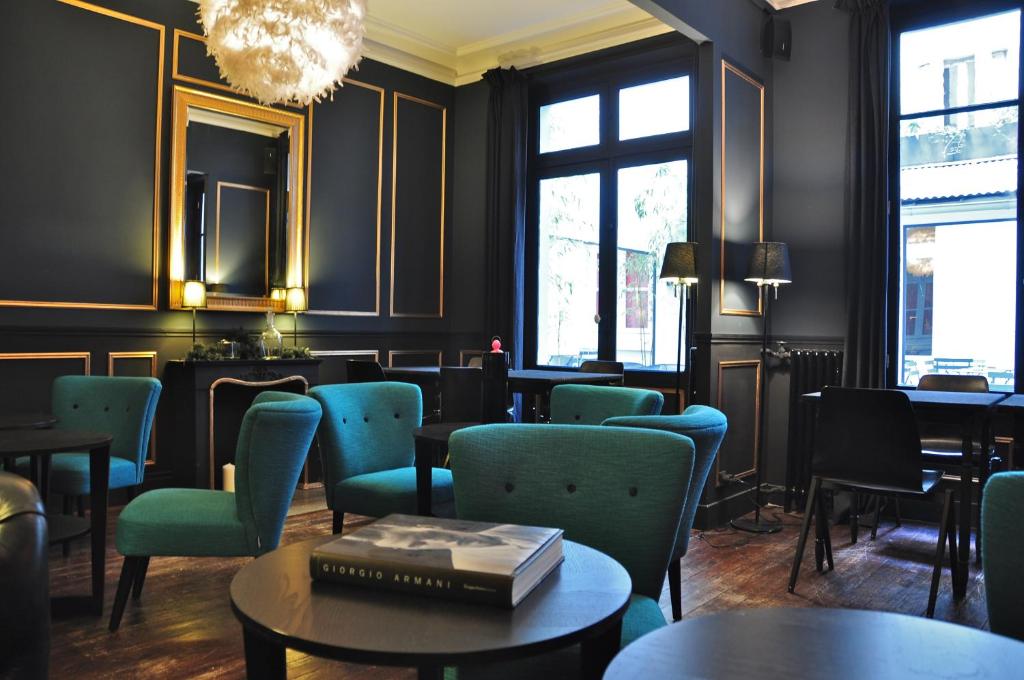 un restaurante con sillas, mesas y una lámpara de araña en Alba Opéra Hôtel, en París
