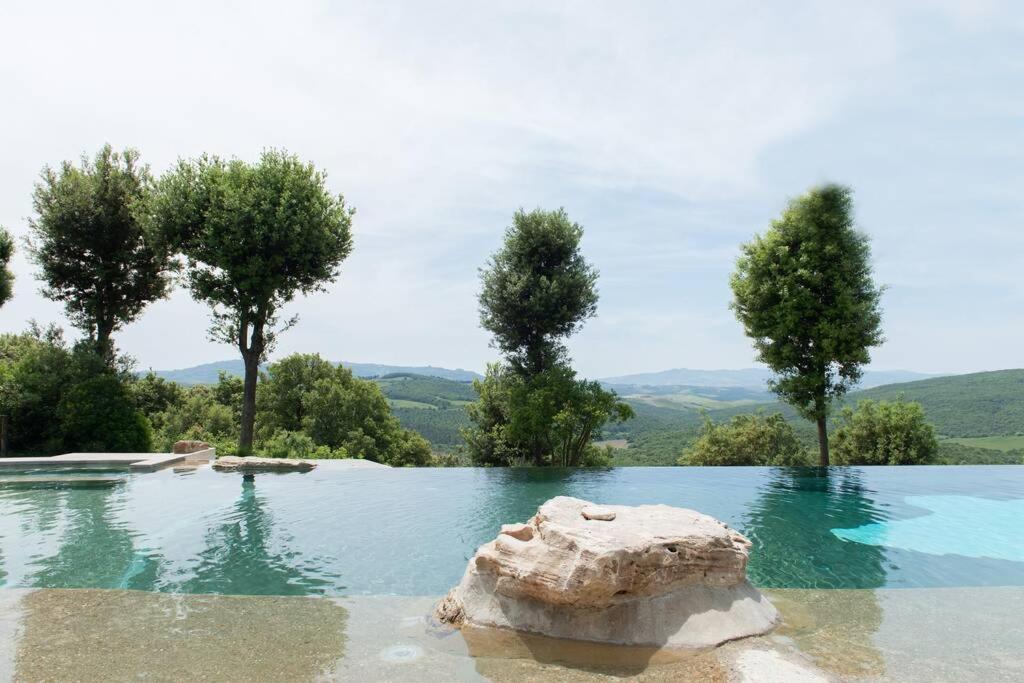 uma piscina com uma rocha na água em Casa Il Corbezzolo in Borgo storico em Gambassi Terme