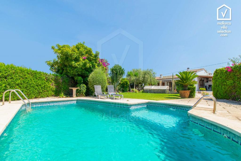 una piscina de agua azul en un patio en Finca MOLI Den FANALS Alcudia, en Alcudia