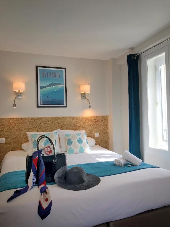 une chambre d'hôtel avec un lit avec un chapeau dessus dans l'établissement Un Hotel sur le Port, à La Rochelle