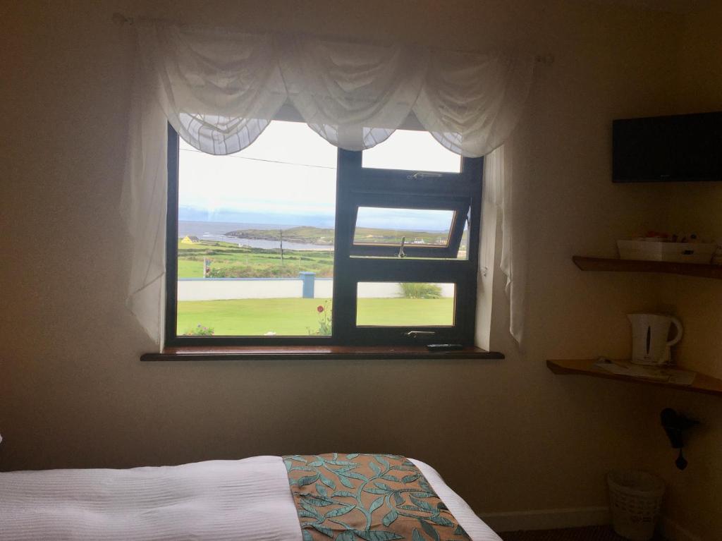 a bedroom with a window with a view of the ocean at Beach View Bed & Breakfast in Allihies
