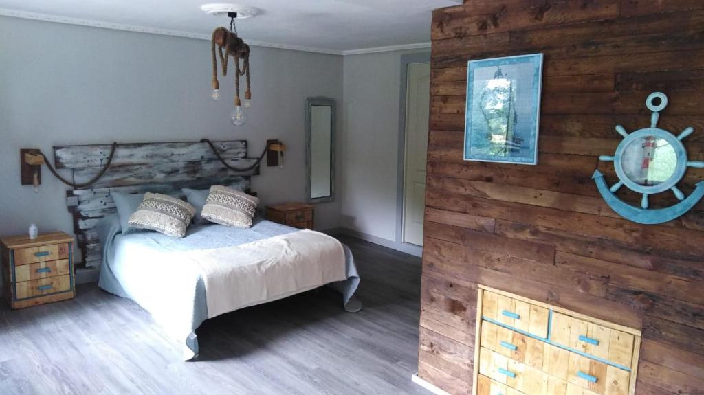 a bedroom with a bed and a wooden wall at Casa Roiz in Santillana del Mar