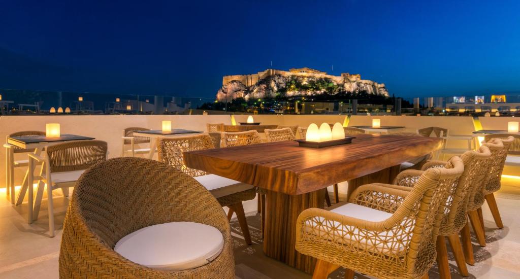 a dining area with tables and chairs and umbrellas at Central Hotel in Athens