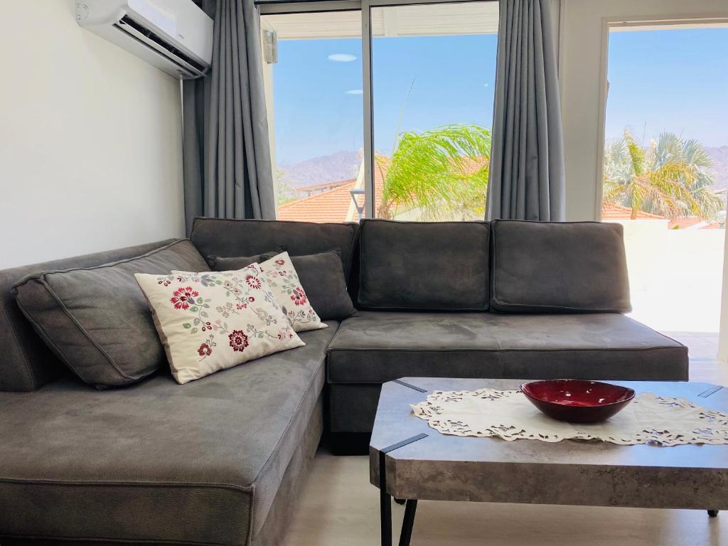 een woonkamer met een bank en een tafel bij Perfect Southern Getaway with Balcony in Eilat