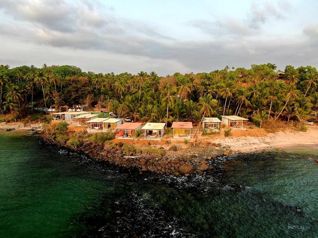 a group of houses on an island in the water at Abidal Resort in Patnem