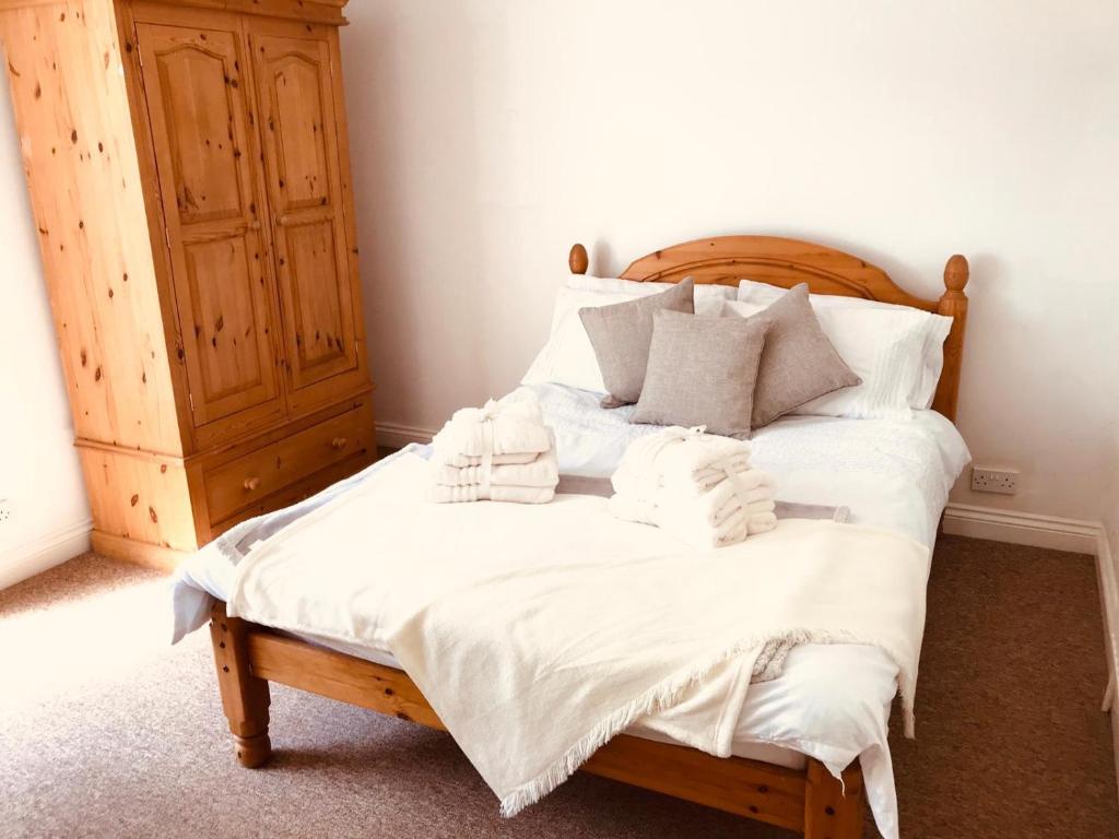 a bedroom with a bed with white sheets and towels at Aston Henry James William Street Close to Reading Town Centre in Reading