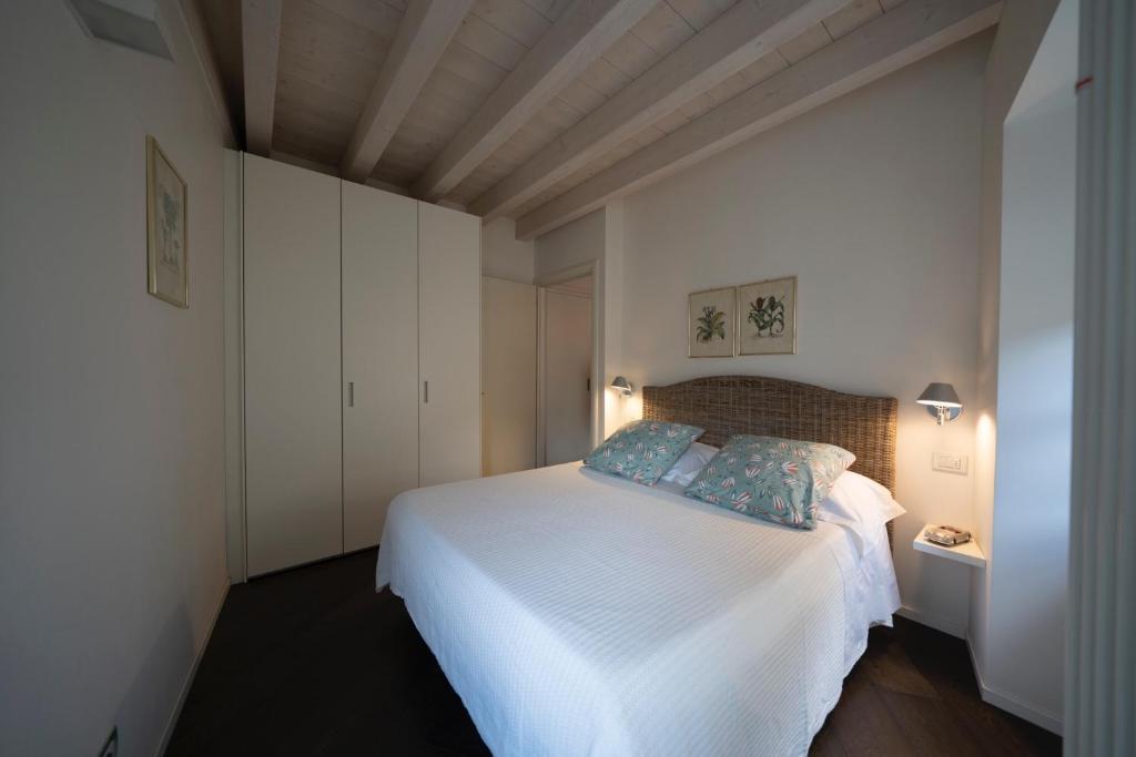 a bedroom with a white bed with blue pillows at La Loggia in Chiavenna
