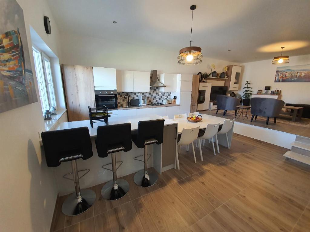 kuchnia i salon ze stołem i krzesłami w obiekcie La Dolce Vita Apartment w mieście Posedarje