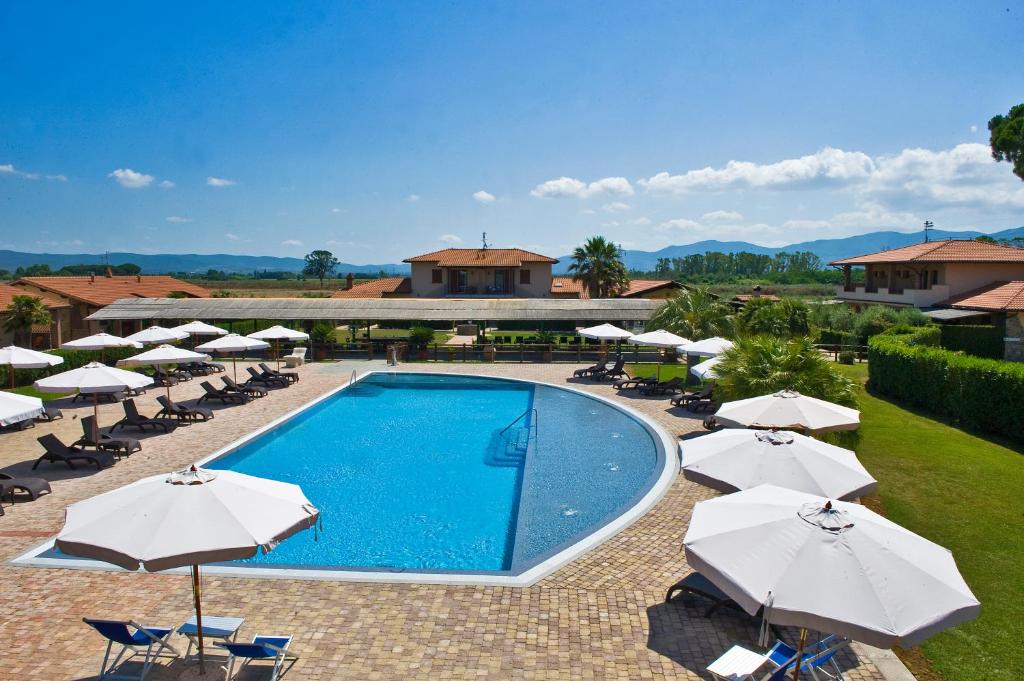 uma piscina com guarda-sóis e cadeiras e um resort em Agriturismo Cannavota em Follonica