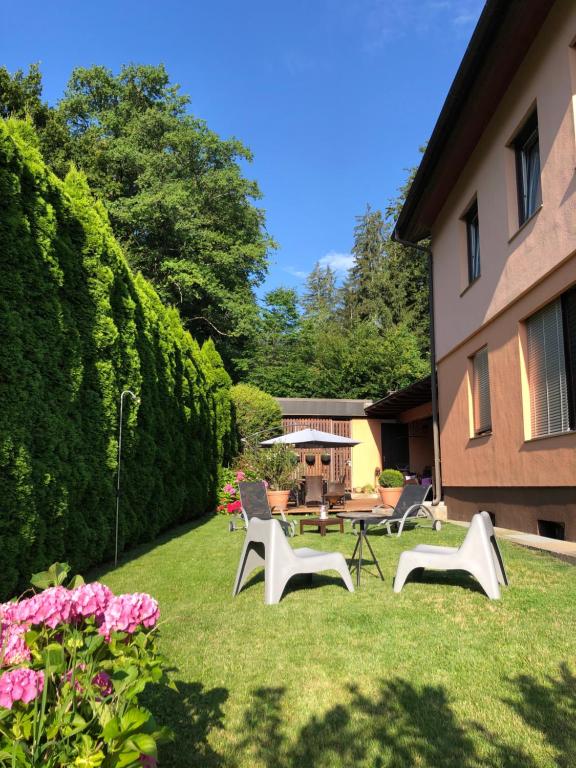 a yard with chairs and a table and flowers at Haus Graf Velden in Velden am Wörthersee