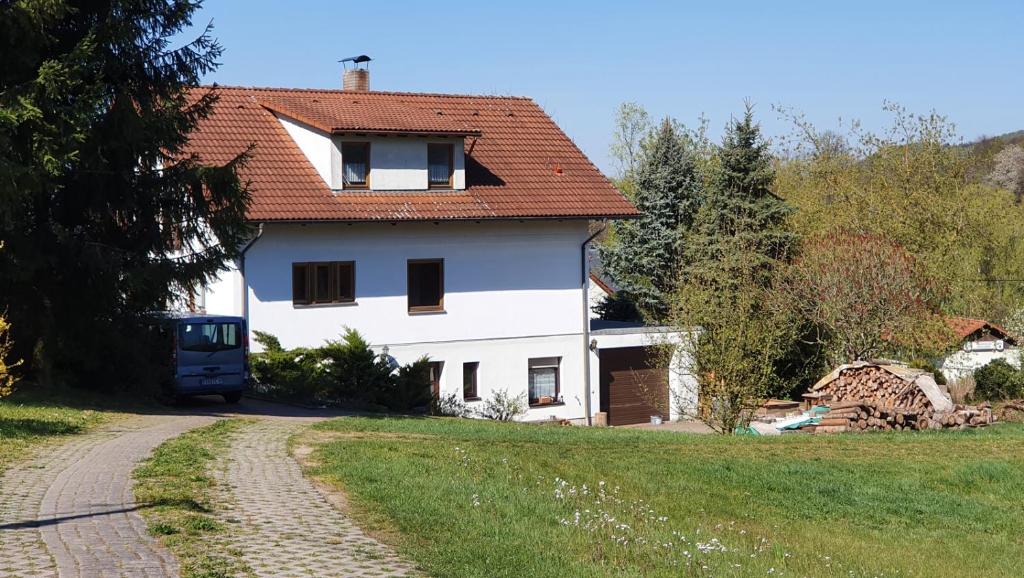 a white house with a red roof and a road at Ferienwohnung Kirnitzschtal in Ottendorf