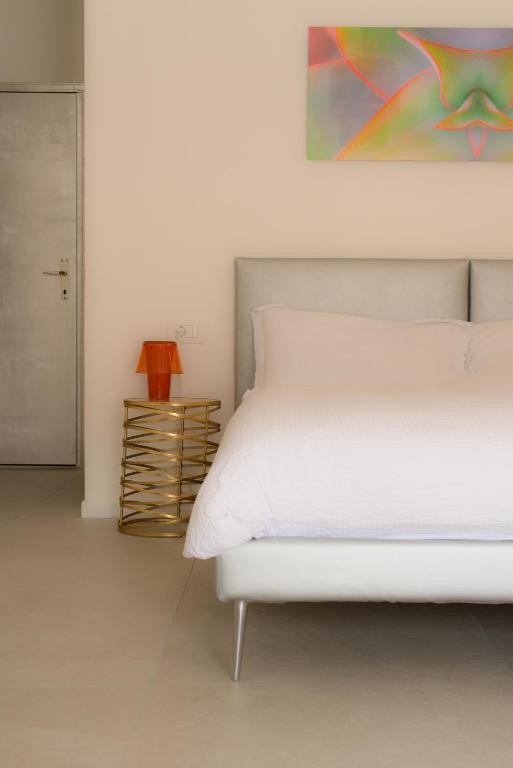 a bedroom with a white bed and a painting on the wall at Emma Suite Merano in Merano