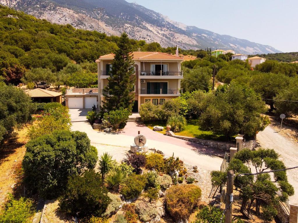 a house in the middle of a garden with trees at Evianna Studios in Mousata