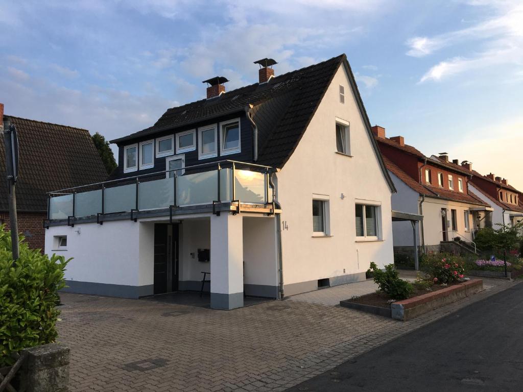 una casa blanca con techo negro en una calle en Ferienwohnung „Im Kleinen Löök“ - DG - 2 Zimmer - Balkon - Boxspringbett - 2 TV, en Rinteln
