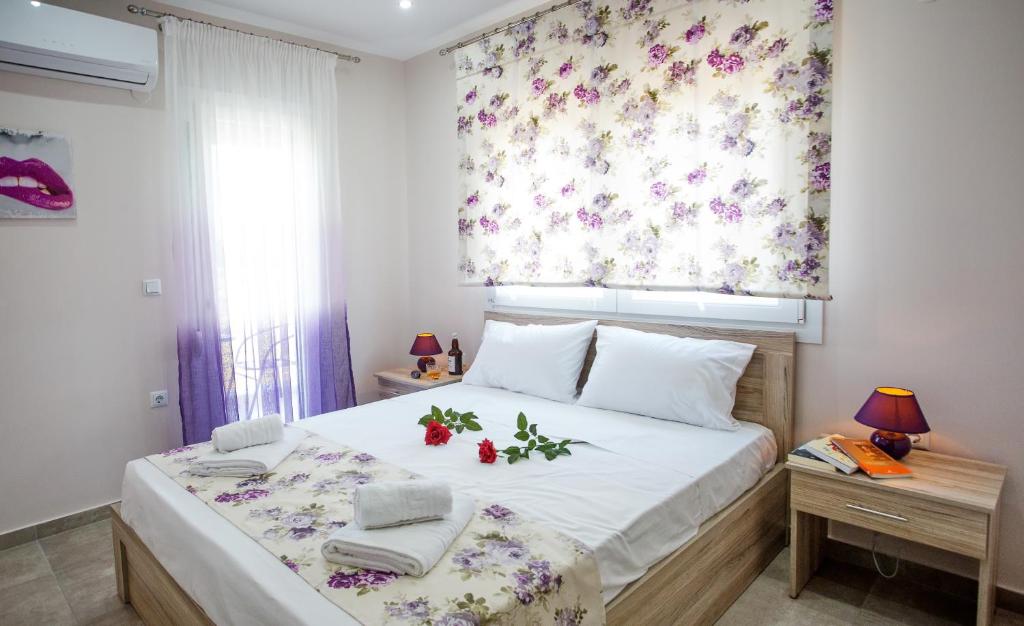a bedroom with a large bed with a floral curtain at Kaiafas Luxury Philoxenia in Néa Péramos