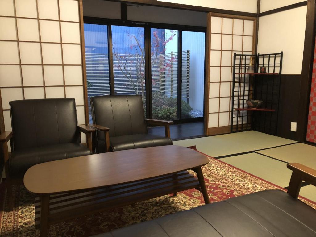 een woonkamer met 2 stoelen en een tafel bij Taisho Aburaya in Takayama