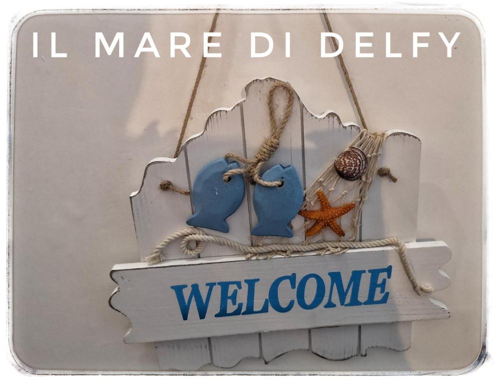 una señal con una señal de bienvenida y una señal que diga bienvenida en Il Mare di Delfy, en Lido di Ostia