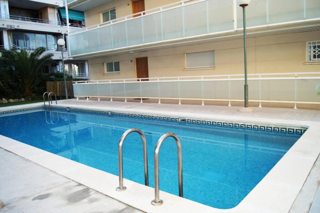 a swimming pool in front of a building at Apartamento Namasté in Salou