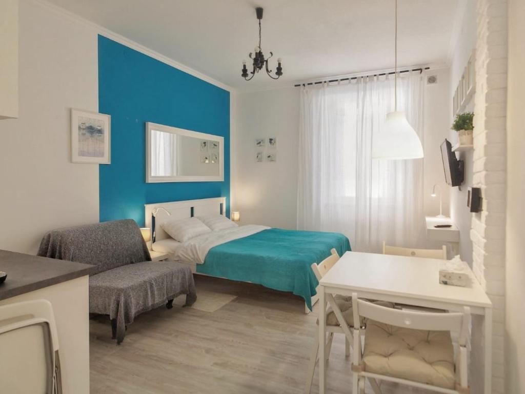 a bedroom with a bed and a couch and a table at Apartmaji Diversorio in Izola