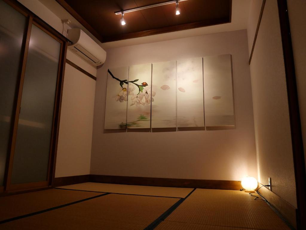 a room with a picture of flowers on the wall at SAKURA Aburaya in Takayama