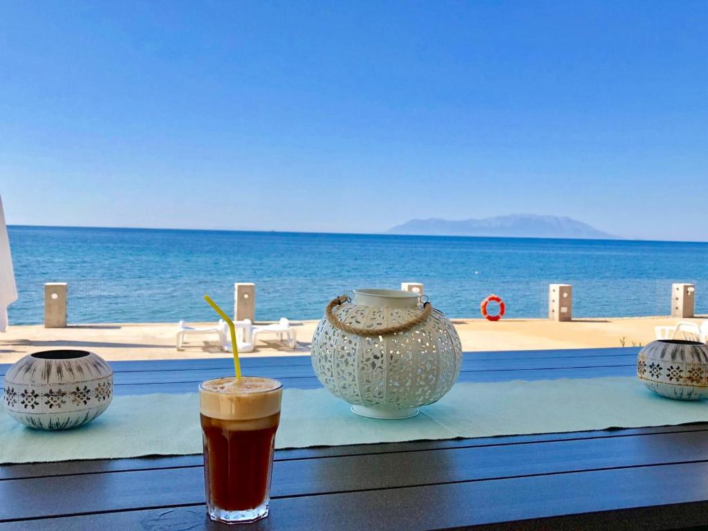 a drink on a table with a view of the ocean at Villa Dimitri - Beach House in Alexandroupoli