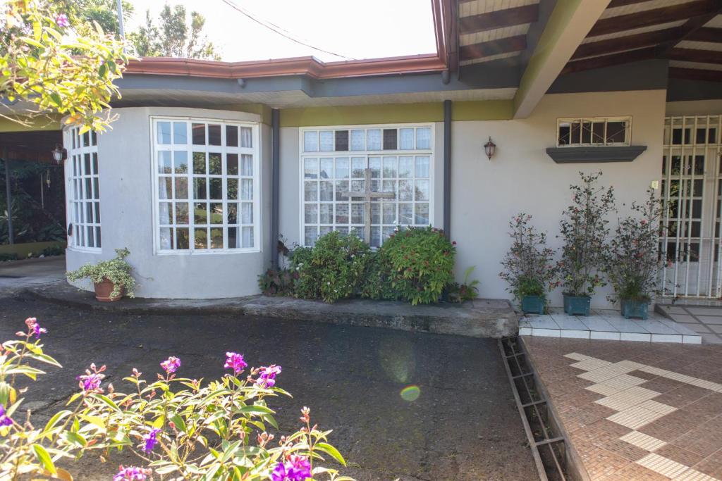 Hostel Bouganvilia Bed and Breakfast في سان رامون: منزل مع حمام سباحة في الفناء الأمامي